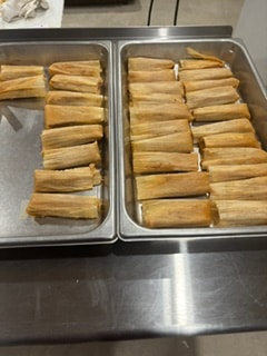 Handmade tamales on a rustic wooden platter