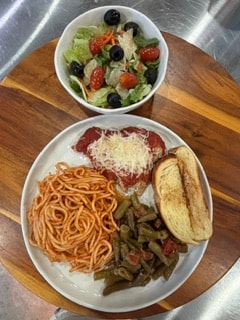 Chicken parmesan plated with a side of green beans